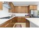 Well-lit kitchen with stainless steel refrigerator, gas range, and abundant cabinet space at 5211 Routt Ct, Arvada, CO 80002