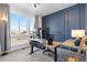 Well-lit home office with dual monitors, a standing desk, and a stylish blue accent wall at 5211 Routt Ct, Arvada, CO 80002
