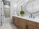 Elegant bathroom featuring dual sinks, wood cabinetry, modern fixtures, and sleek round mirrors at 1587 Arrowpoint Ct, Franktown, CO 80116