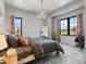 Bright bedroom showcasing large windows with scenic views, a decorative antler chandelier, and modern stylish decor at 1587 Arrowpoint Ct, Franktown, CO 80116