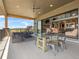 Spacious covered patio with comfortable seating, an outdoor dining area, and serene views of the surrounding landscape at 1587 Arrowpoint Ct, Franktown, CO 80116