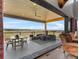 Expansive covered patio offers panoramic views, comfortable lounge seating, and an elegant outdoor dining set at 1587 Arrowpoint Ct, Franktown, CO 80116