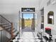 Grand foyer with black and white tiled floor, staircase and view to exterior at 1587 Arrowpoint Ct, Franktown, CO 80116