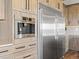 A stainless steel refrigerator and built-in coffee maker complement wood cabinetry in this gourmet kitchen at 1587 Arrowpoint Ct, Franktown, CO 80116