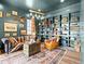 A unique sitting room features custom built-ins, a leather couch, and eclectic decorations at 1587 Arrowpoint Ct, Franktown, CO 80116