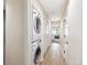 Hallway featuring a stacked washer and dryer and access to another room at 3030 Wyandot St # 4, Denver, CO 80211