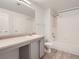 Bright bathroom featuring a sink, large mirror, and a shower-tub combo at 7440 S Blackhawk St # 9-108, Englewood, CO 80112