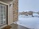 A cozy condo entrance shows brick exterior, a covered porch, with snow-covered parking in the community at 7440 S Blackhawk St # 9-108, Englewood, CO 80112