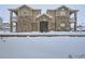 Condominium exterior with stone facade and snow-covered grounds, creating a cozy winter scene at 7440 S Blackhawk St # 9-108, Englewood, CO 80112