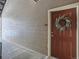 Condo front door with wreath hanging on the door and wood-look siding providing a welcoming entrance at 7440 S Blackhawk St # 9-108, Englewood, CO 80112