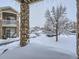 A charming two-story condo with stone pillars, snow-covered yards and trees in a cozy community at 7440 S Blackhawk St # 9-108, Englewood, CO 80112