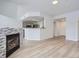 Open-concept living area with stone fireplace, wood floors, and view into kitchen with breakfast bar at 7440 S Blackhawk St # 9-108, Englewood, CO 80112