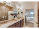 Bright bathroom with double vanity, large mirror, modern lighting, and a view to the bedroom at 903 W 129Th Pl, Westminster, CO 80234