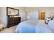 Comfortable bedroom with dark dresser, cozy armchair, and doorway leading to additional rooms at 903 W 129Th Pl, Westminster, CO 80234