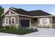 Charming home featuring stone accents, a dark garage door, and a beautifully landscaped front yard at 903 W 129Th Pl, Westminster, CO 80234