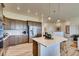 Modern kitchen with a center island, stainless steel appliances, and adjacent living spaces at 903 W 129Th Pl, Westminster, CO 80234
