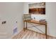Neat laundry room with wooden table, modern decor, and wood-style flooring at 903 W 129Th Pl, Westminster, CO 80234