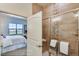 Shower with decorative tile and clear glass door, adjacent to a light-filled bedroom at 903 W 129Th Pl, Westminster, CO 80234