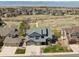 An aerial view of the lovely home situated on a large lot with a scenic backdrop of trees and the mountains beyond at 9895 Wyecliff Dr, Highlands Ranch, CO 80126