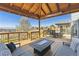 Relaxing covered back deck with mountain views, outdoor seating and fire pit at 9895 Wyecliff Dr, Highlands Ranch, CO 80126