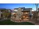 The backyard features the deck, patio, and manicured lawn with a mature tree at 9895 Wyecliff Dr, Highlands Ranch, CO 80126