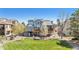 Expansive backyard featuring a wooden deck, well-maintained lawn, mature trees, and a solar panel system at 9895 Wyecliff Dr, Highlands Ranch, CO 80126