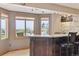 Basement bar area with large windows, granite countertops, and stylish seating at 9895 Wyecliff Dr, Highlands Ranch, CO 80126