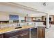 Finished basement bar with granite countertop, sink, wine fridge, and open to Gathering space at 9895 Wyecliff Dr, Highlands Ranch, CO 80126