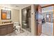 Modern bathroom with tile shower, vanity, and open layout to basement entertaining space at 9895 Wyecliff Dr, Highlands Ranch, CO 80126