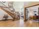 Inviting foyer with hardwood floors, staircase, and entry to the living room and office at 9895 Wyecliff Dr, Highlands Ranch, CO 80126