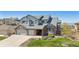 Charming two-story home featuring a manicured lawn, brick accents, and a spacious three-car garage at 9895 Wyecliff Dr, Highlands Ranch, CO 80126