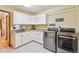 Functional laundry room features modern washer and dryer and plenty of cabinet space at 9895 Wyecliff Dr, Highlands Ranch, CO 80126
