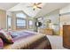 Bright main bedroom with a view, vaulted ceilings, ensuite bathroom, and a ceiling fan at 9895 Wyecliff Dr, Highlands Ranch, CO 80126