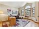 Well-lit office space featuring a large arched window, hardwood floors, and ample workspace at 9895 Wyecliff Dr, Highlands Ranch, CO 80126