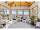 Bright sun room with vaulted ceiling and walls of windows offering mountain views at 9895 Wyecliff Dr, Highlands Ranch, CO 80126