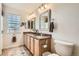Bathroom featuring double sinks, granite counters, framed mirrors, and decorative light fixtures at 9486 Elmhurst Ln # D, Highlands Ranch, CO 80129