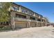 View of modern townhome featuring attached garages, stone accents, and upper level balconies at 9486 Elmhurst Ln # D, Highlands Ranch, CO 80129