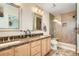 Bright and modern main bathroom with double vanity, framed mirrors, and glass shower at 9486 Elmhurst Ln # D, Highlands Ranch, CO 80129