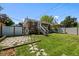 A spacious backyard with a stone patio, grassy area, and a privacy fence provides a serene outdoor living space at 2430 S Ogden St, Denver, CO 80210