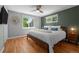 A serene bedroom with hardwood floors, two windows, and a comfortable king bed at 2430 S Ogden St, Denver, CO 80210