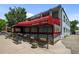 John Holly's Asian Bistro with red awning, outdoor seating, and accessible ramp, perfect for casual or formal dining at 2430 S Ogden St, Denver, CO 80210