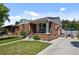 Lovely home with a well-manicured lawn, brick facade, and inviting front porch at 2430 S Ogden St, Denver, CO 80210