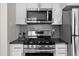 Stainless steel Samsung oven, microwave, and gas range with grey subway tile backsplash at 2430 S Ogden St, Denver, CO 80210