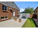Brick home boasts a lovely patio with seating, a grill, and flower pots, ideal for outdoor enjoyment and entertaining at 2430 S Ogden St, Denver, CO 80210