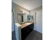 Bathroom vanity featuring granite countertops, dark wood cabinets and modern fixtures at 16136 E Exposition Dr, Aurora, CO 80017