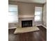 Close up of a fireplace with white trim, brick surround and wood flooring at 16136 E Exposition Dr, Aurora, CO 80017