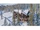 Stunning log cabin home surrounded by snow-covered trees, featuring a stone foundation and inviting balconies at 351 Kimmes Ln, Breckenridge, CO 80424