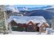 Beautiful log cabin covered in snow, surrounded by mountain scenery on a bright day at 351 Kimmes Ln, Breckenridge, CO 80424