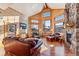 Spacious living room boasting a stone fireplace, wood accents, expansive windows with mountain views, and leather furnishings at 351 Kimmes Ln, Breckenridge, CO 80424