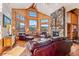 Inviting living room with wood paneling, stone fireplace, large windows showcasing mountain views, and leather seating at 351 Kimmes Ln, Breckenridge, CO 80424